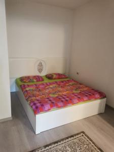 a bed with a colorful comforter in a room at PRISHTINA Stay in Prishtinë