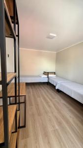 an empty room with two beds in it at Aydin Guest House in Bayetovka +7 photos
