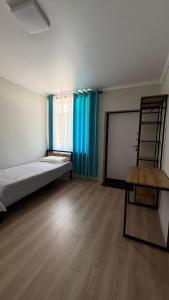 a room with a bed and a ladder and a table at Aydin Guest House in Bayetovka