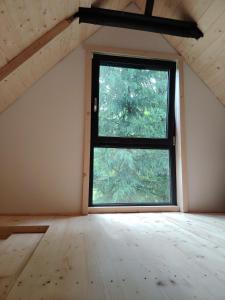 an empty room with a window in a attic at Casuta dintre brazi in Râșca