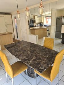 a kitchen with a black marble table and chairs at FV Dwelling in Hucknall