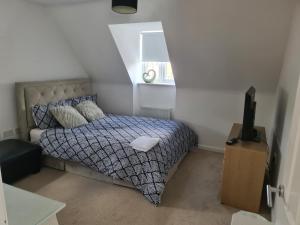 a bedroom with a bed and a television in it at FV Dwelling in Hucknall