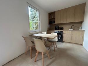a kitchen with a table and chairs and a window at Prázdninový domeček in Heřmanice +5 photos