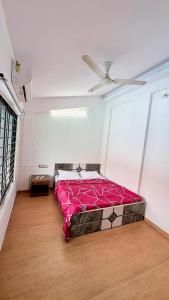 a bed in a room with a ceiling fan at 7 Stone in Malavli