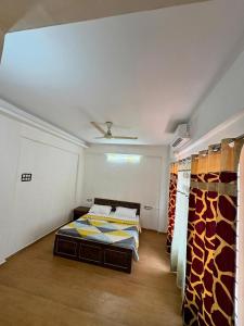 a room with two beds and curtains in it at 7 Stone in Malavli