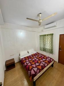 a bedroom with a bed and a ceiling fan at 7 Stone in Malavli