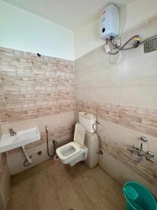 a bathroom with a toilet and a sink at 7 Stone in Malavli