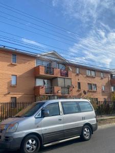 a silver van parked in front of a brick building at Comfortable apartment steps from Portal Belloto in Quilpué