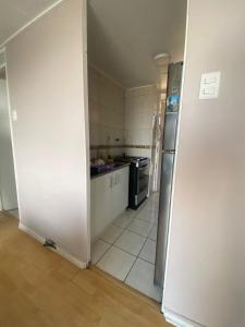 a kitchen with a stove and a refrigerator at Comfortable apartment steps from Portal Belloto in Quilpué +10 photos