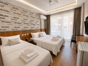 a hotel room with two beds with towels on them at mood beach hotel in Didim +32 photos