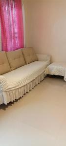 a couch in a room with a pink window at Rooms in Bloom in Tarlac