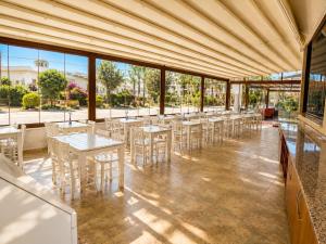 a dining room with tables and chairs and windows at mood beach hotel in Didim