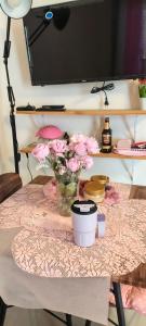 a table with a vase of pink flowers on it at Rooms in Bloom in Tarlac