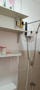 a bathroom with a white toilet and a shelf at Rooms in Bloom in Tarlac