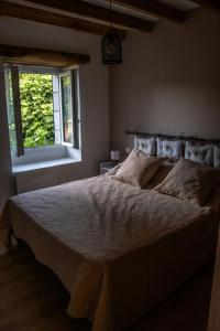 a bedroom with a large bed with a window at Lacour in Augignac