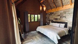 a bedroom with a bed and a brick wall at Hotel Villas Mariposas in Atlixco +44 photos