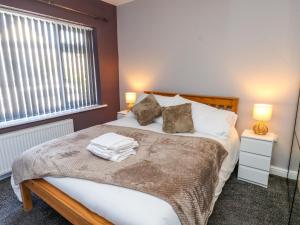 a bedroom with a bed with two lamps and a window at Ger y Mynydd, 2 Cae Ty Coch in Brynteg