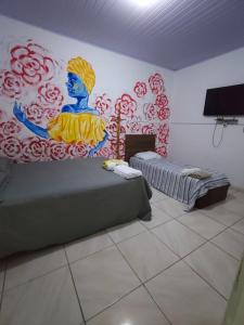 a room with two beds and a painting on the wall at durmaaquislz in São Luís