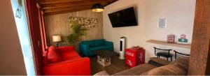 a living room with red and blue furniture and a tv at Hotel Villas Mariposas in Atlixco