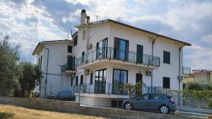 a car parked in front of a white house at Affittacamere Domus Roseto in Roseto Capo Spulico