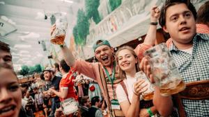 a group of people cheering at a beer festival at Munich Oktoberfest Village Breakfast included by Yes-Trips! in Munich