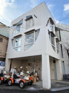a white house with three atvs parked in front of it at Moon Base Tokyo Inn in Tokyo
