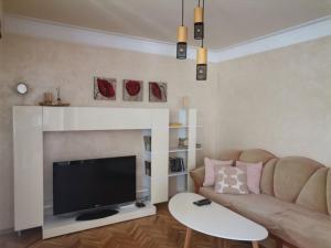 a living room with a couch and a television at Апартамент Граф Игнатиев in Varna City