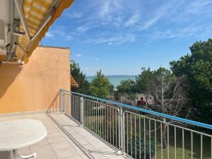 a balcony with a table and a view of the water at Apartman Jasmine in Csopak