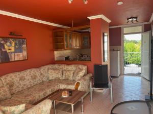 a living room with a couch and a table at Apartman Jasmine in Csopak +12 photos