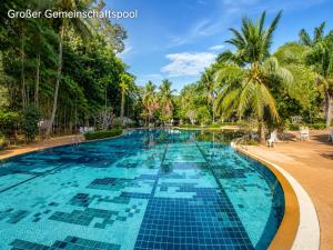 a swimming pool at a resort with palm trees at Oceanside Place in Rayong