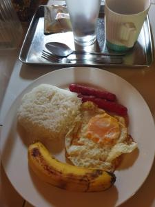 a plate of breakfast food with a banana and eggs at Era's Garden Homestay in Catmon