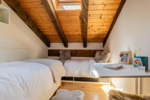 a bedroom with two beds and a wooden ceiling at The Haven Quiet Escape - Panoramic Terrace in Valtournenche