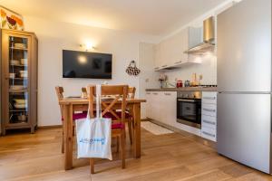 a kitchen with a table and a white refrigerator at The Haven Quiet Escape - Panoramic Terrace in Valtournenche
