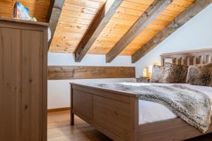 a bedroom with wooden ceilings and a large bed at The Haven Quiet Escape - Panoramic Terrace in Valtournenche