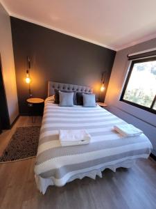 a large white bed in a room with a window at Depto Premium Ski-in Ski-out Edificio Alerces-Nevados de Chillán in Nevados de Chillan +51 photos