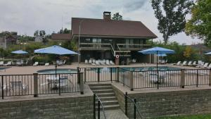 a building with a pool with umbrellas and chairs at Bears Among Us in Gatlinburg