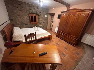 a bedroom with a bed and a wooden table at Casa Rural Villacampa (Nocito) in Nocito