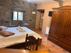 a bedroom with a large bed and a wooden cabinet at Casa Rural Villacampa (Nocito) in Nocito