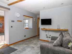 a living room with a couch and a tv at The Milk Shed in Plymtree