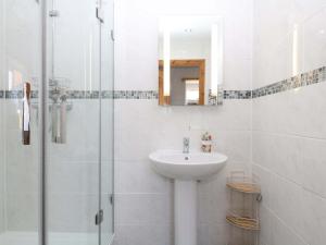 a white bathroom with a sink and a shower at The Milk Shed in Plymtree +20 photos