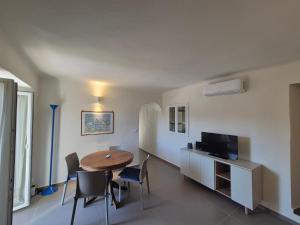 a room with a table and chairs and a television at Rezzano 12 in Bonassola