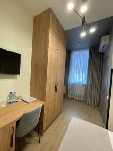 a room with a desk and a large wooden cabinet at Farmer`s Hotel in Pereiaslav-Khmelnytskyi