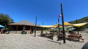 a pavilion with a yellow tent and tables and benches at Depto Premium Ski-in Ski-out Edificio Alerces-Nevados de Chillán in Nevados de Chillan