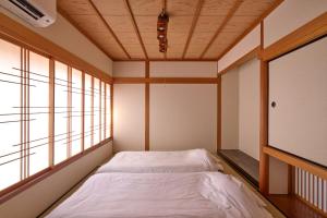 a bedroom with a bed and a flat screen tv at Kanazawa Machiya Kasaichi - Entire House Free Parking in Kanazawa