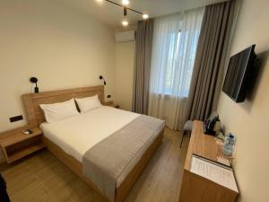 a hotel room with a bed and a television at Farmer`s Hotel in Pereiaslav-Khmelnytskyi