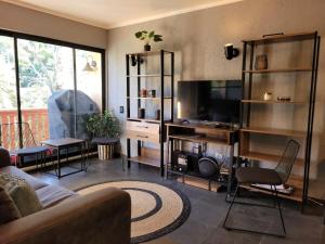 a living room with a couch and a television at Depto Premium Ski-in Ski-out Edificio Alerces-Nevados de Chillán in Nevados de Chillan