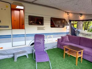 a purple couch and a table in a caravan at Kanukamp, Kemping nad rzeką in Tarnogóra