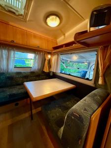 a living room with a table and a couch in an rv at Kanukamp, Kemping nad rzeką in Tarnogóra +52 photos