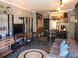 a living room with a couch and a kitchen at Depto Premium Ski-in Ski-out Edificio Alerces-Nevados de Chillán in Nevados de Chillan