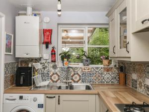 a kitchen with a sink and a window at Mei's Cottage in Exeter